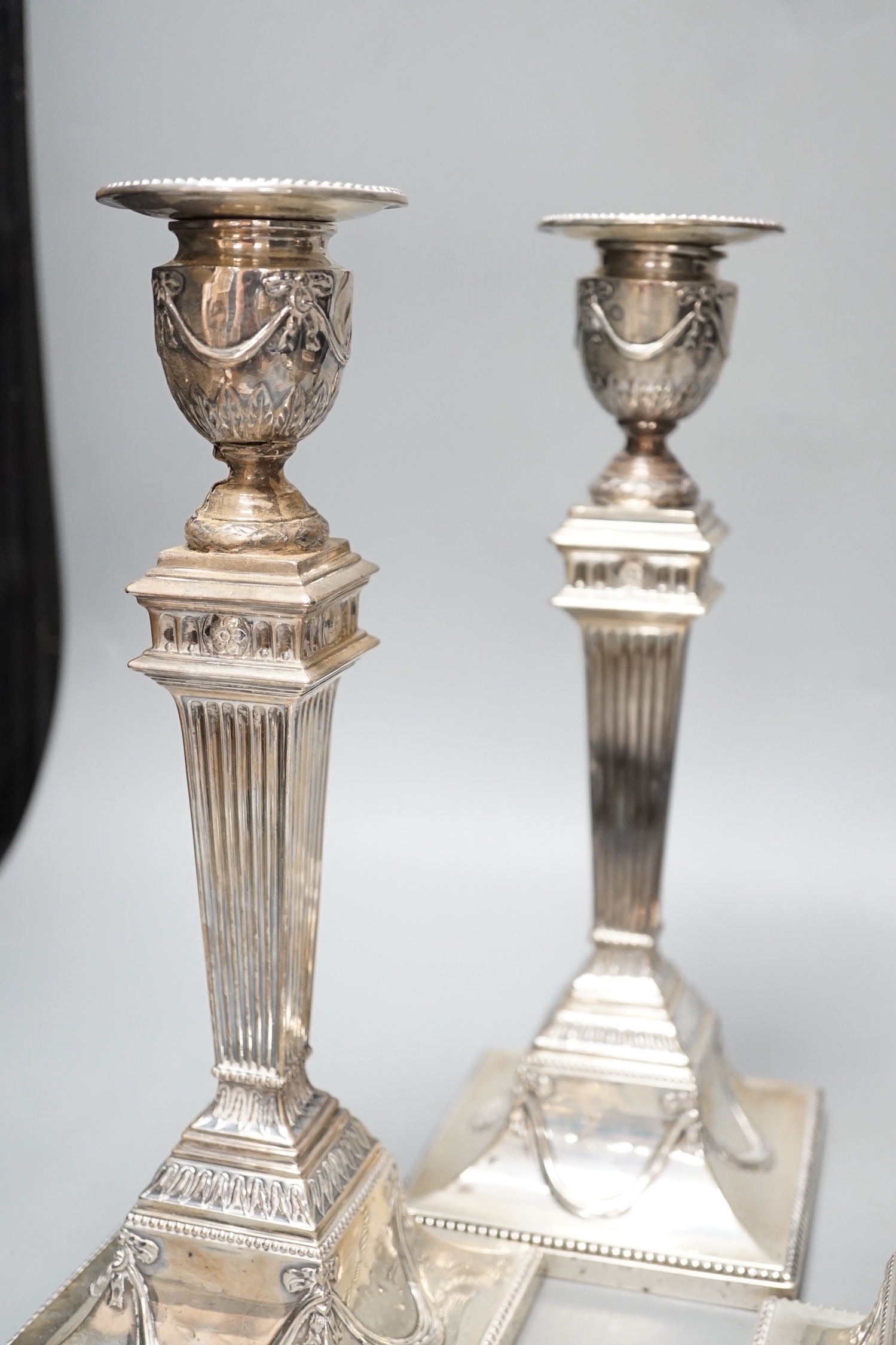 A set of four late Victorian silver candlesticks, with fluted, tapered stems, Hawksworth, Eyre & Co, Sheffield, 1890, 27.5cm, weighted (a.f.).